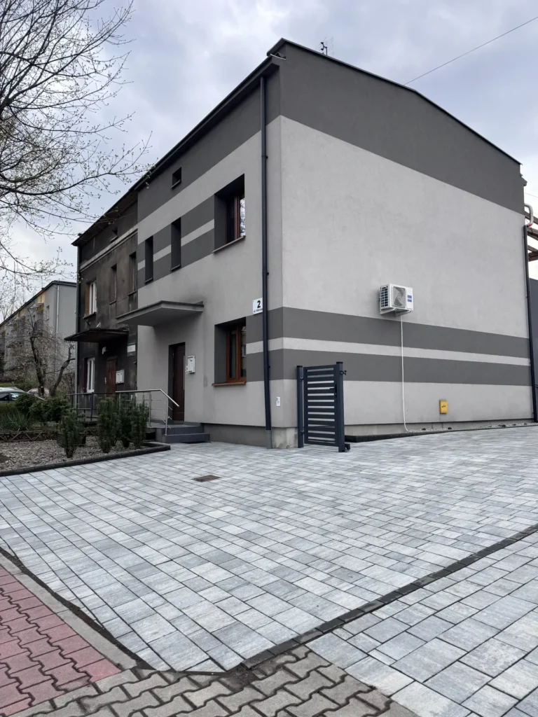 Zauważalny efekt zmycia kostki brukowej przy zabudowie wielorodzinnej.